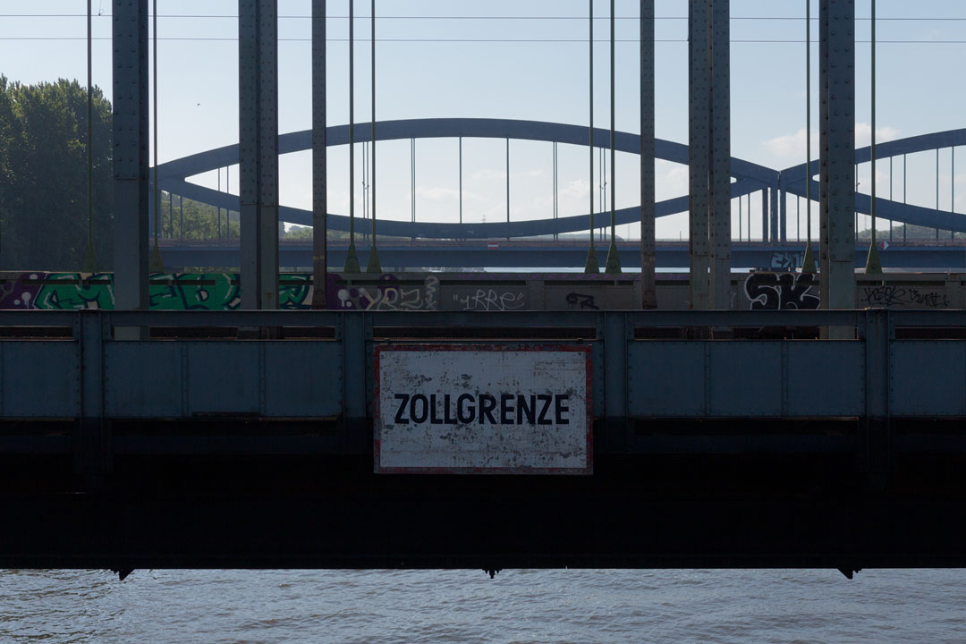 Zollgrenze-Schild an der Eisenbahnbrücke.